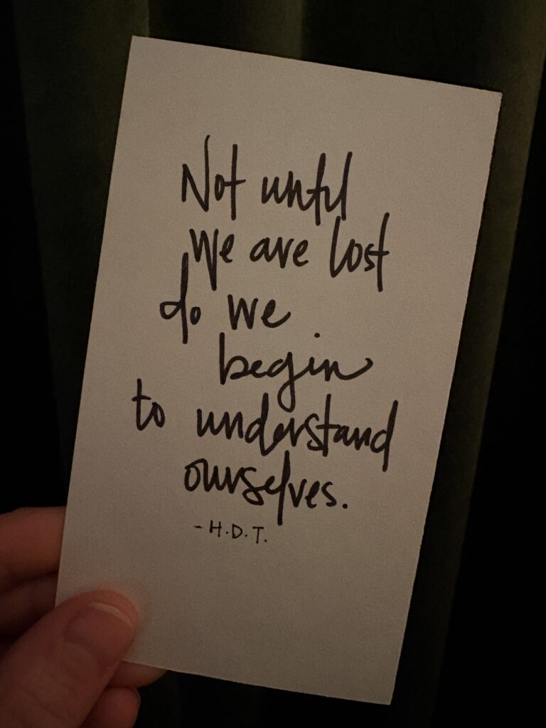a notecard with the quote "not until we are lost do we begin to understand ourselves by Henry David Thoreau